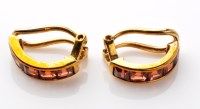 Lot 718 - A pair of garnet ear clips, each of half hoop...