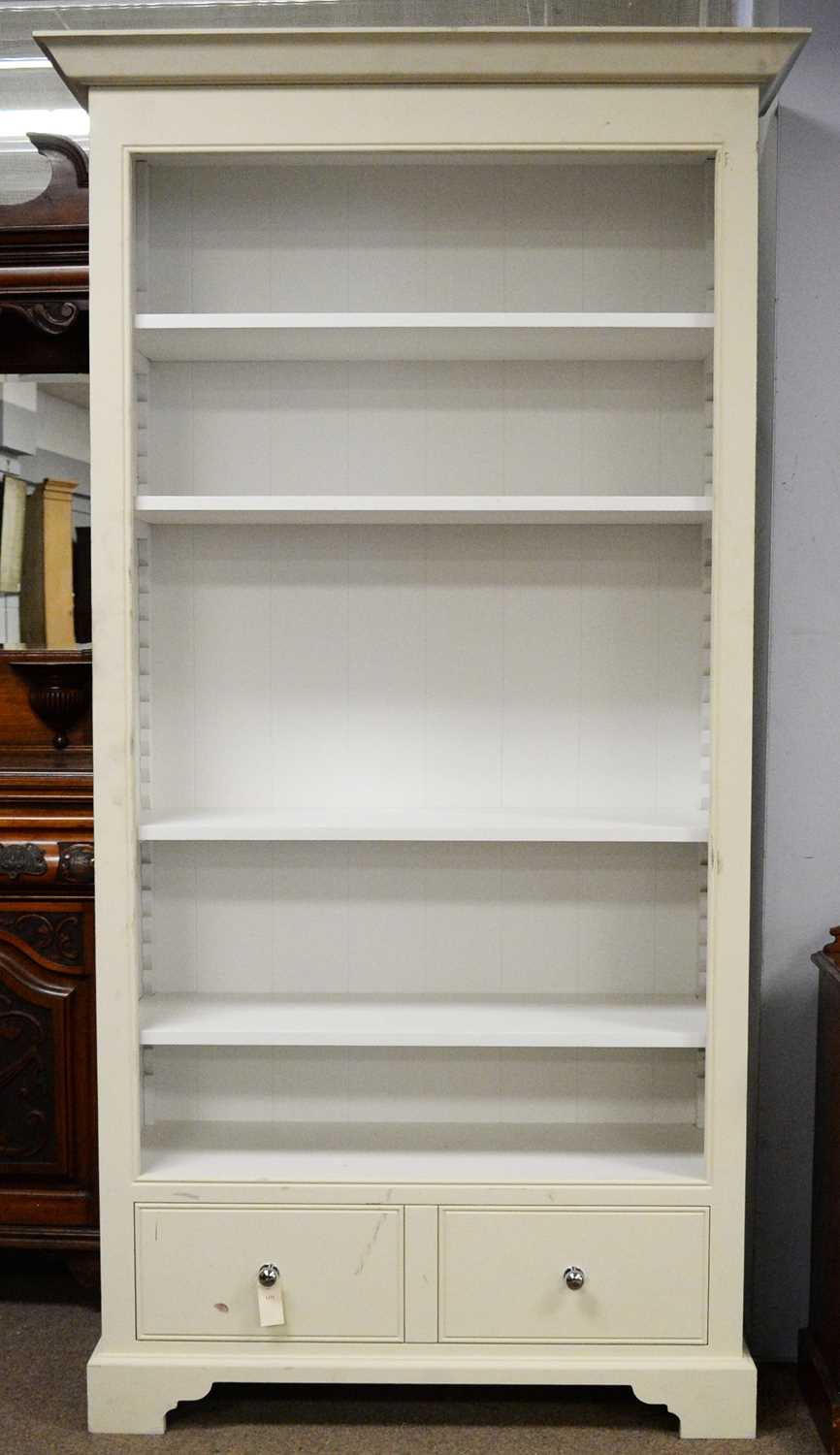 Lot 54 - A cream painted open bookcase.