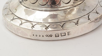 Lot 37 - A pair of George V arts and crafts silver vases with flaring rims