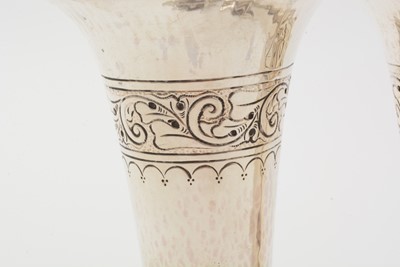 Lot 37 - A pair of George V arts and crafts silver vases with flaring rims