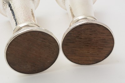 Lot 37 - A pair of George V arts and crafts silver vases with flaring rims