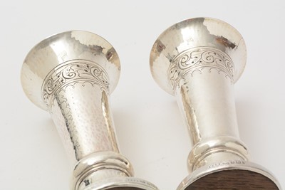 Lot 37 - A pair of George V arts and crafts silver vases with flaring rims