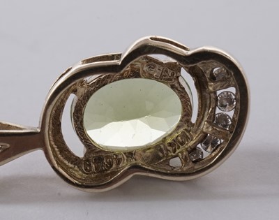 Lot 57 - A peridot and diamond pendant; and a pair of matching earrings