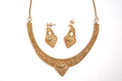 Lot 1255 - An Indian high carat yellow gold necklace and matching earrings