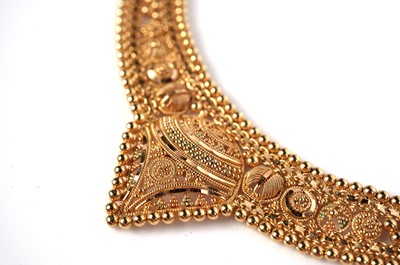 Lot 1255 - An Indian high carat yellow gold necklace and matching earrings