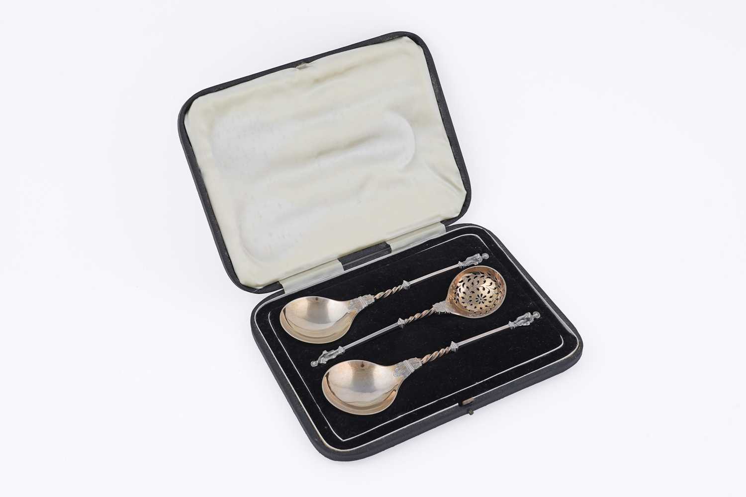 Lot 10 - A Victorian cased pair of silver parcel-gilt fruit serving spoons and matching sugar sifter spoon