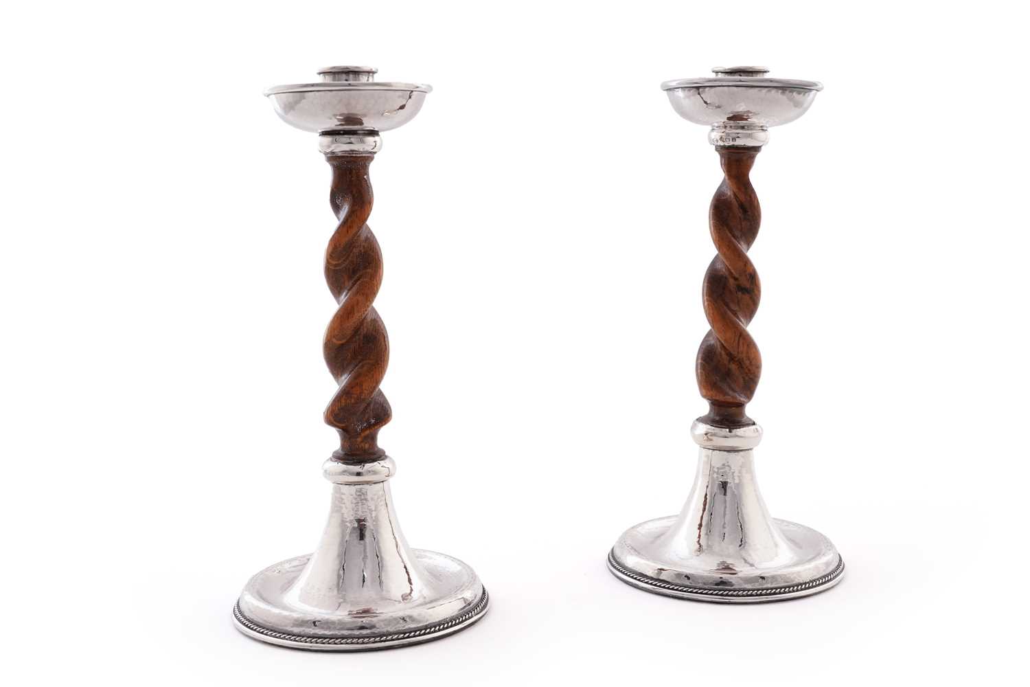 Lot 47 - A pair of George V arts and crafts silver mounted candlesticks