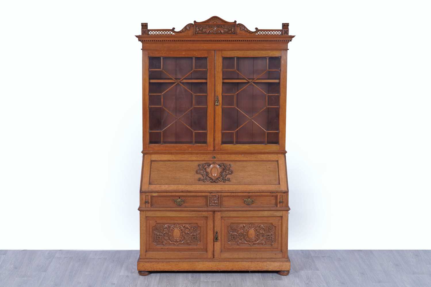 Lot 22 - Robson & Sons Newcastle upon Tyne: an early 20th Century carved oak bureau bookcase