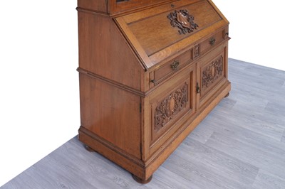 Lot 22 - Robson & Sons Newcastle upon Tyne: an early 20th Century carved oak bureau bookcase