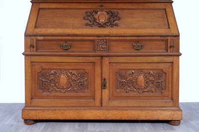 Lot 22 - Robson & Sons Newcastle upon Tyne: an early 20th Century carved oak bureau bookcase