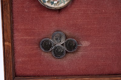 Lot 38 - A framed display of Victorian and later jewellery and accoutrements