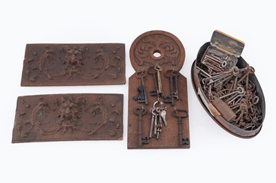 Lot 465 - Two carved panels and a selection of keys