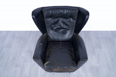 Lot 64 - A 1950’s black leather wingback revolving armchair