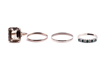 Lot 252 - Rings including: a citrine dress ring; and an emerald half hoop eternity ring