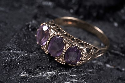 Lot 35 - An Edwardian style three-stone amethyst ring
