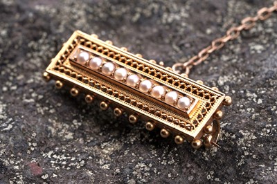 Lot 130 - A Victorian Etruscan Revival 15ct gold and seed pearl bar brooch