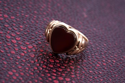 Lot 84 - An Edwardian loveheart pattern carnelian signet ring