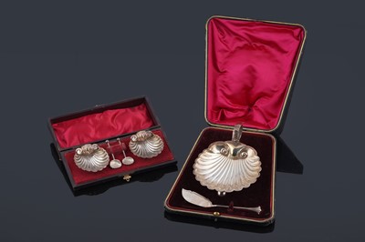 Lot 206 - A cased Edwardian silver shell-pattern butter dish, and a cased pair of similar salts